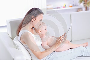 Mother and baby are looking to play and read tablet computer