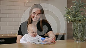 Mother and baby are looking to play and read tablet computer on the couch at home