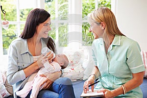 Mother With Baby Meeting With Health Visitor At Home photo