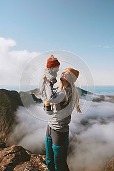 Mother with baby on mountain top family hiking in mountains vacation outdoor cheerful woman with child healthy lifestyle