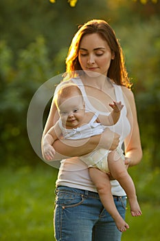 Mother and baby outdoors. Mother holding baby on her arms