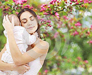 Mother with baby over spring garden background photo