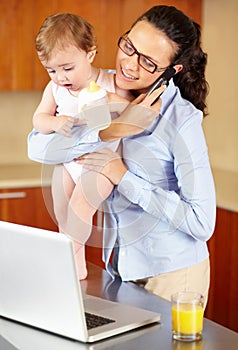 Mother, baby and phone call on laptop for work from home, business planning and multitasking in kitchen. Single mom