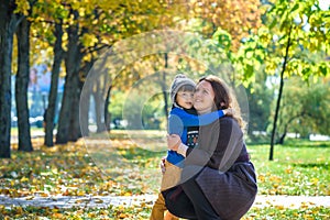 Mother and baby play in autumn park. Parent and child walk in the forest on a sunny fall day. Children playing outdoors with