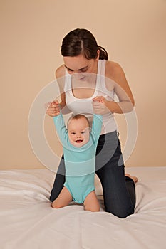 Mother with baby playing in bed