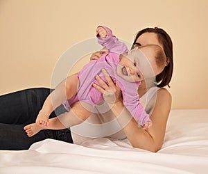Mother with baby playing in bed