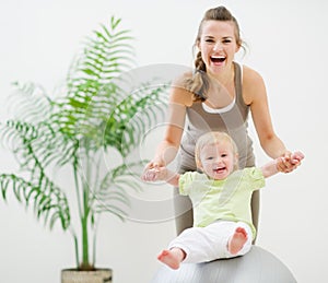 Mother and baby playing with fitness ball