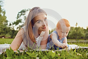 Mother and baby playing on grass in  park.