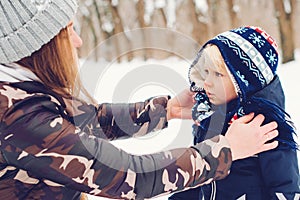 Mother and baby playing in snow. Frost winter snowy weather. Happy family on a winter walk. Winter outwear fashion