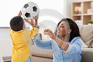 Mother and baby playing with soccer ball at home