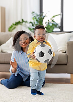 Mother and baby playing with soccer ball at home