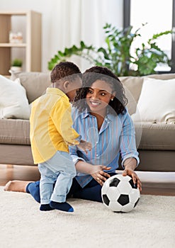 Mother and baby playing with soccer ball at home