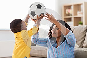 Mother and baby playing with soccer ball at home