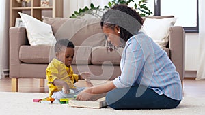Mother and baby playing with toy blocks at home