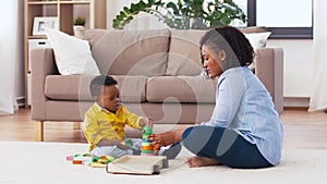 Mother and baby playing with toy blocks at home