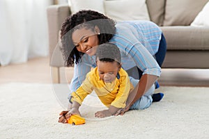 Mother and baby playing with toy car at home