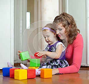 Mother and baby plays with toys