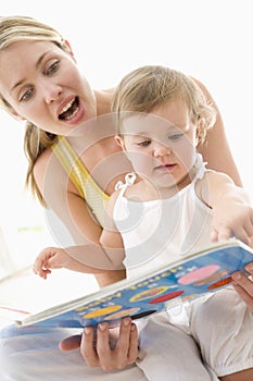 Mother and baby reading book indoors