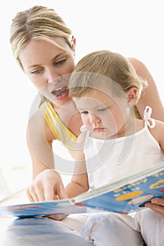 Mother and baby reading book indoors