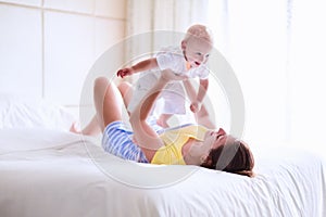 Mother and baby relaxing in white bedroom