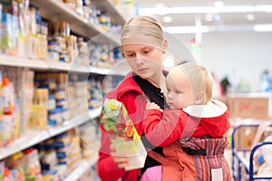 Mother with baby shopping in supermarket