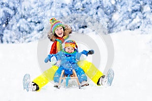 Mother and baby on sleigh ride. Winter snow fun.