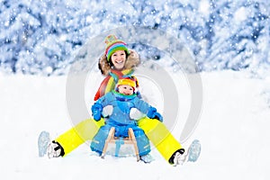 Mother and baby on sleigh ride. Winter snow fun.