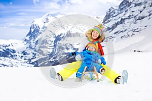 Mother and baby on sleigh ride. Winter snow fun