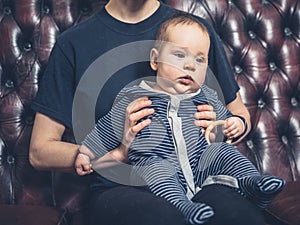 Mother and baby on sofa watching television