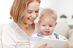 Mother and baby son with a tablet computer at home