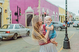 Mother and baby son tourists explore the vibrant streets of Valladolid, Mexico, immersing herself in the rich culture