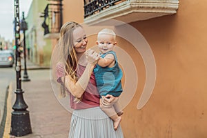 Mother and baby son tourists explore the vibrant streets of Valladolid, Mexico, immersing herself in the rich culture