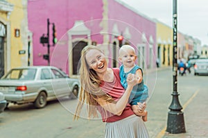 Mother and baby son tourists explore the vibrant streets of Valladolid, Mexico, immersing herself in the rich culture