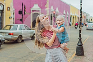 Mother and baby son tourists explore the vibrant streets of Valladolid, Mexico, immersing herself in the rich culture