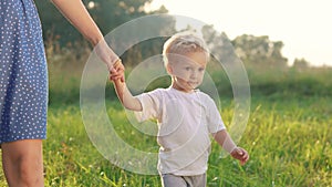 mother and baby a son walking in the park. happy family walking in the park in nature relaxing outdoors. happy family