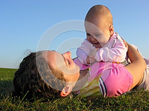 Mother with baby on sunset lie photo