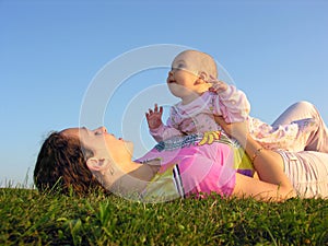 Mother with baby on sunset lie