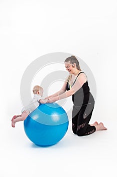 mother with baby suspended holding his head up on a gymnastic ball