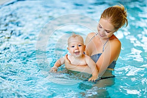 Mother and baby swim in pool