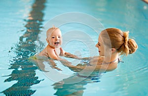 Mother and baby swim in pool