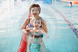 Mother and baby swim in the pool. Healthy family mother teaching baby swimming pool