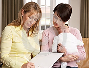 Mother With Baby Talking With Health Visitor photo