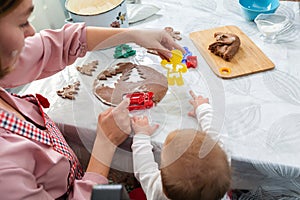 Mother and baby together cut out cookies from the dough. Top view. Mother& x27;s Day concept and cooking festive home