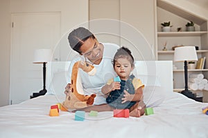 Mother, baby and toys for learning, education and development with building blocks and teddy bear on a bed in a home