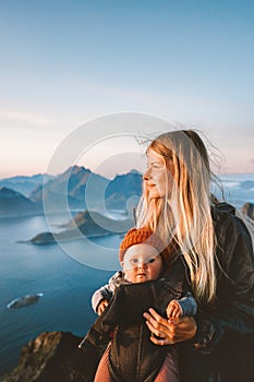 Mother with baby traveling in Norway family healthy lifestyle outdoor summer vacations woman hiking with infant child