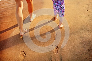 Mother and baby walking along the beach.