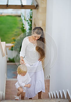 Mother and baby walking up stairs