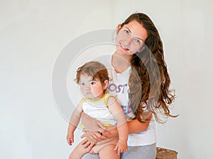 Mother with baby on a white background. Happy family laughing faces, mother holding adorable child baby boy, smiling and hugging,