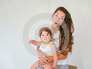 Mother with baby on a white background. Happy family laughing faces, mother holding adorable child baby boy, smiling and hugging,