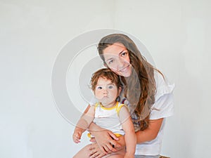 Mother with baby on a white background. Happy family laughing faces, mother holding adorable child baby boy, smiling and hugging,